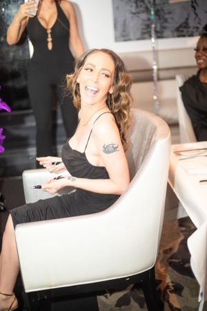 Party guest in black dress enjoying celebration in modern venue setting.