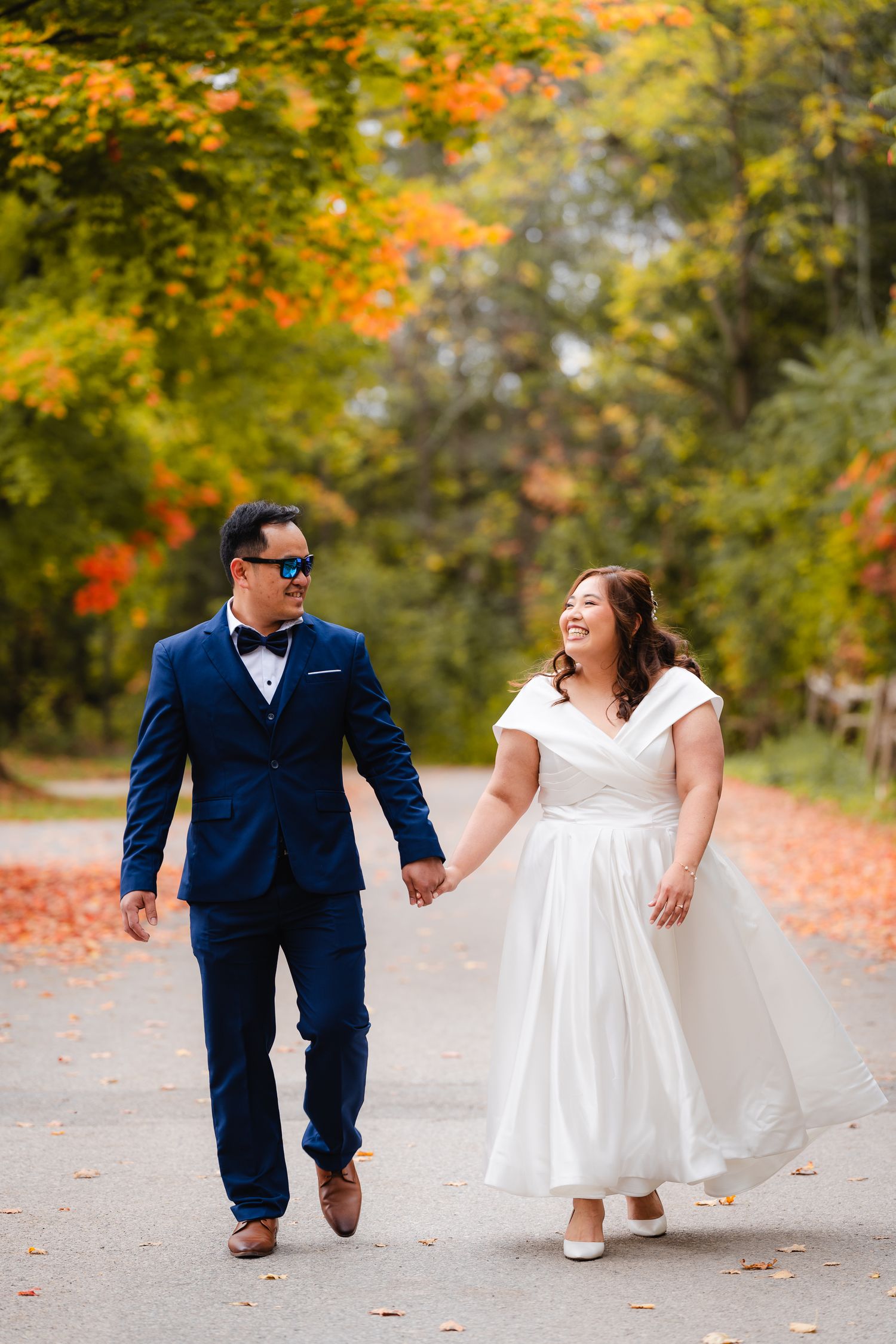 Groom and Bride walking and holding hands together in autumn