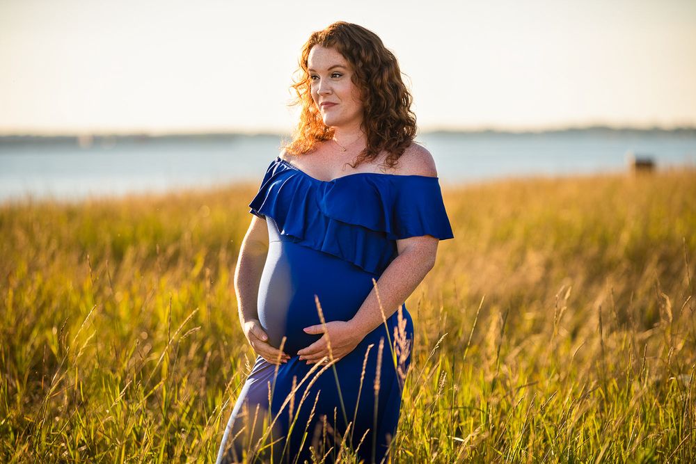 Golden hour maternity photo at Outer Harbor in Buffalo, NY, capturing a glowing expectant mom.