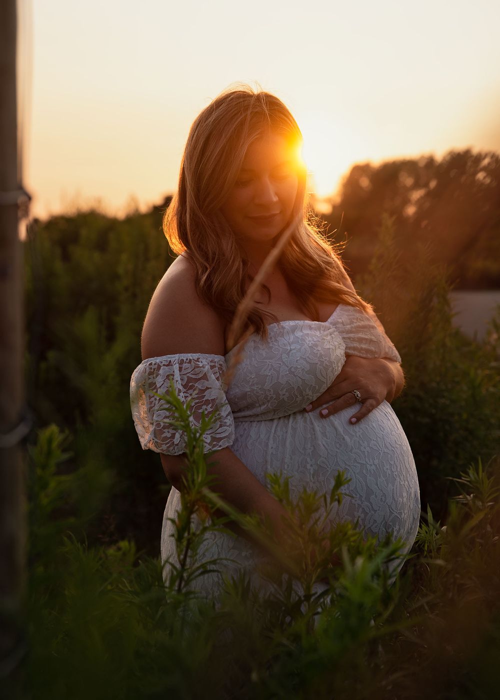 Golden hour maternity photo at Outer Harbor in Buffalo, NY, capturing a glowing expectant mom.