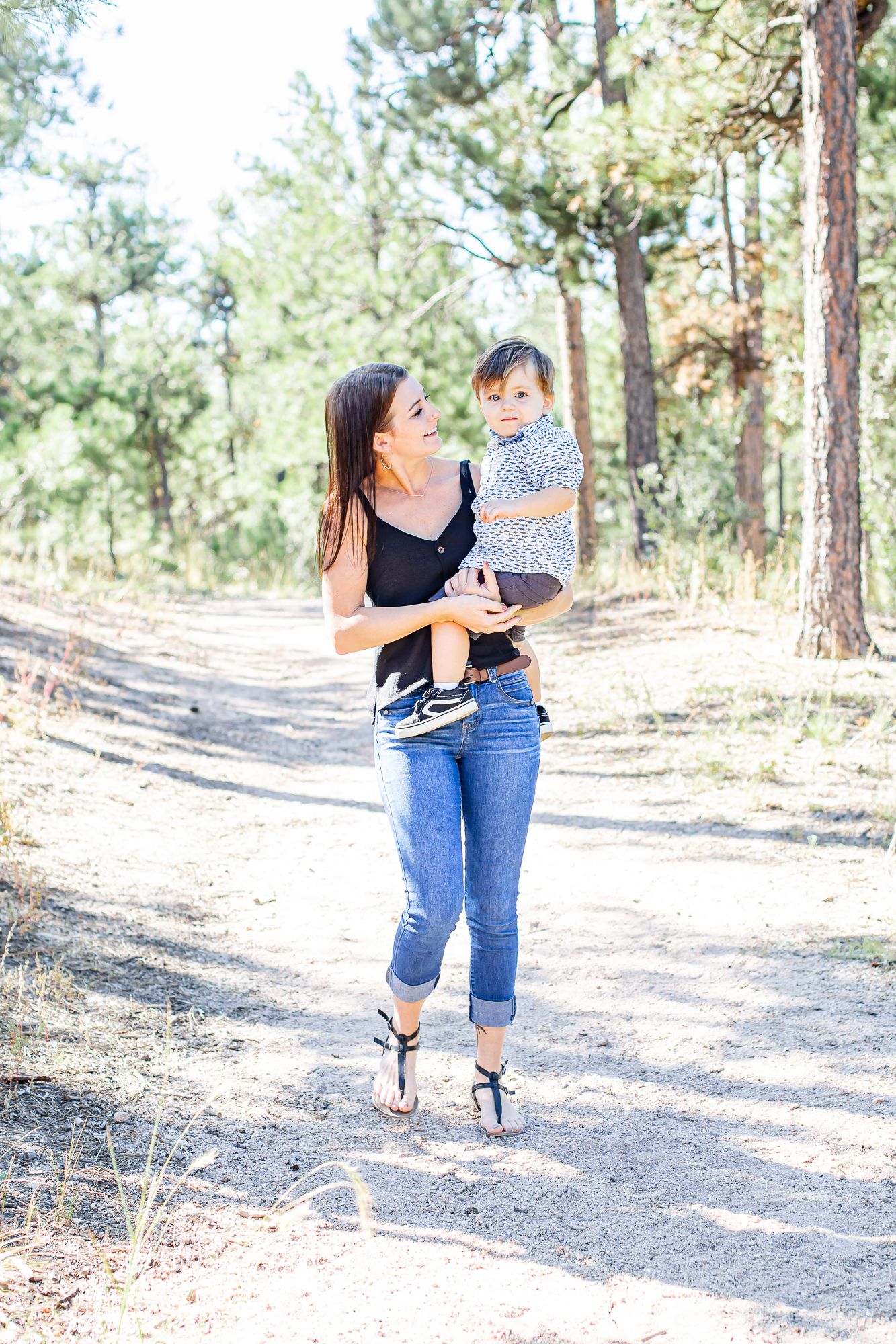 Mom carries her toddler boy down the trail in Black Forest, Colorado.