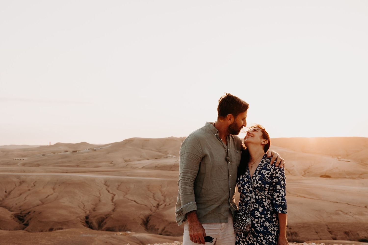 Romantic sunset moment against desert landscape backdrop.