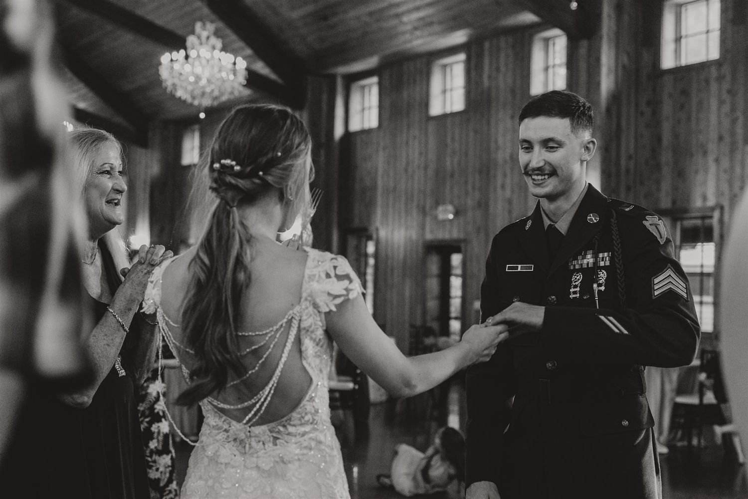 A couple shares a special moment during their reception in an elegant wood-paneled ballroom.