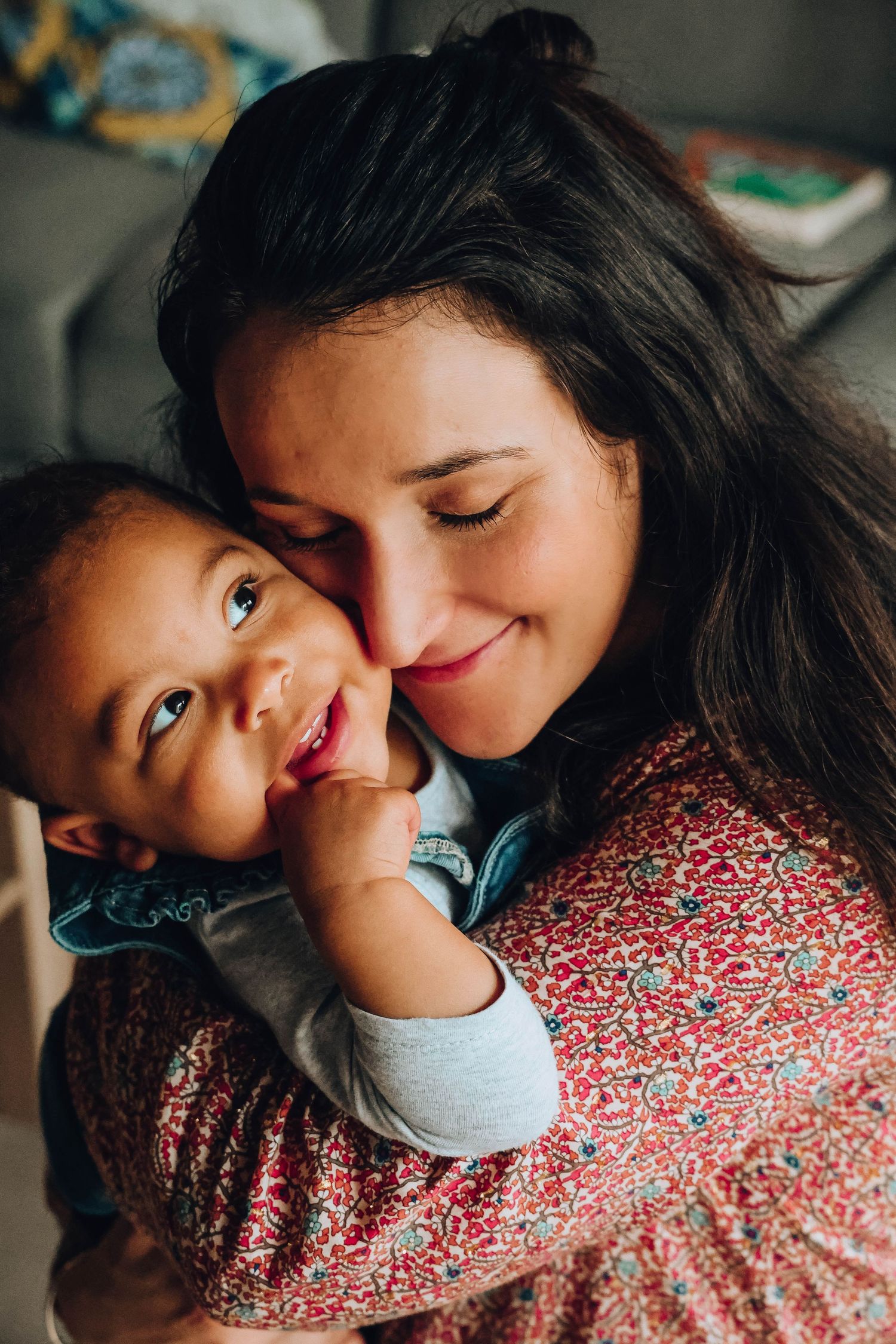 Candid close-up of joyful moment shared between adult and child in warm lighting.