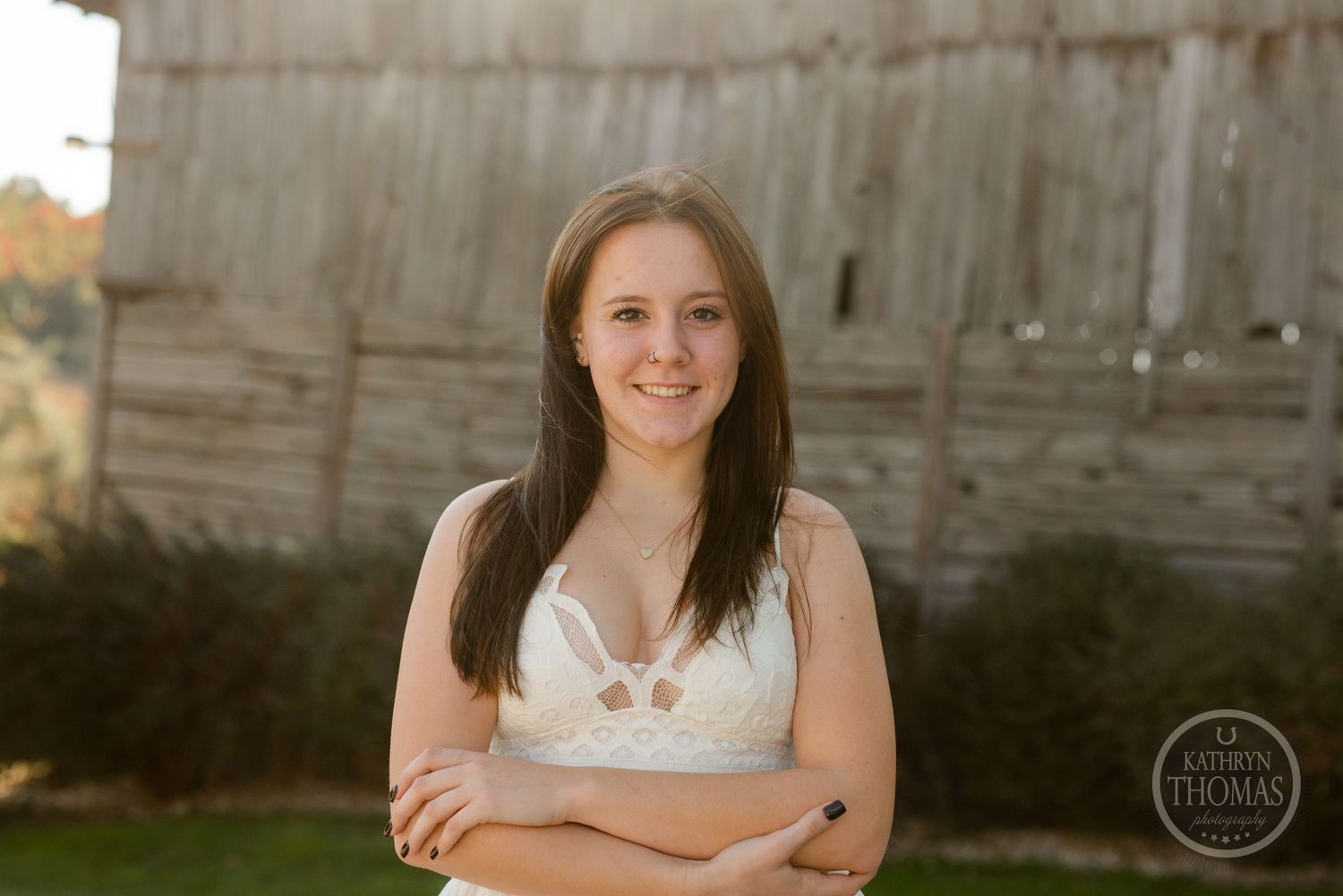 Portrait in front of rustic barn with warm sunset lighting.