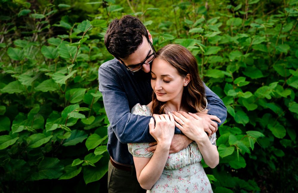 Intimate couple portraits captured among lush green foliage in a natural setting.