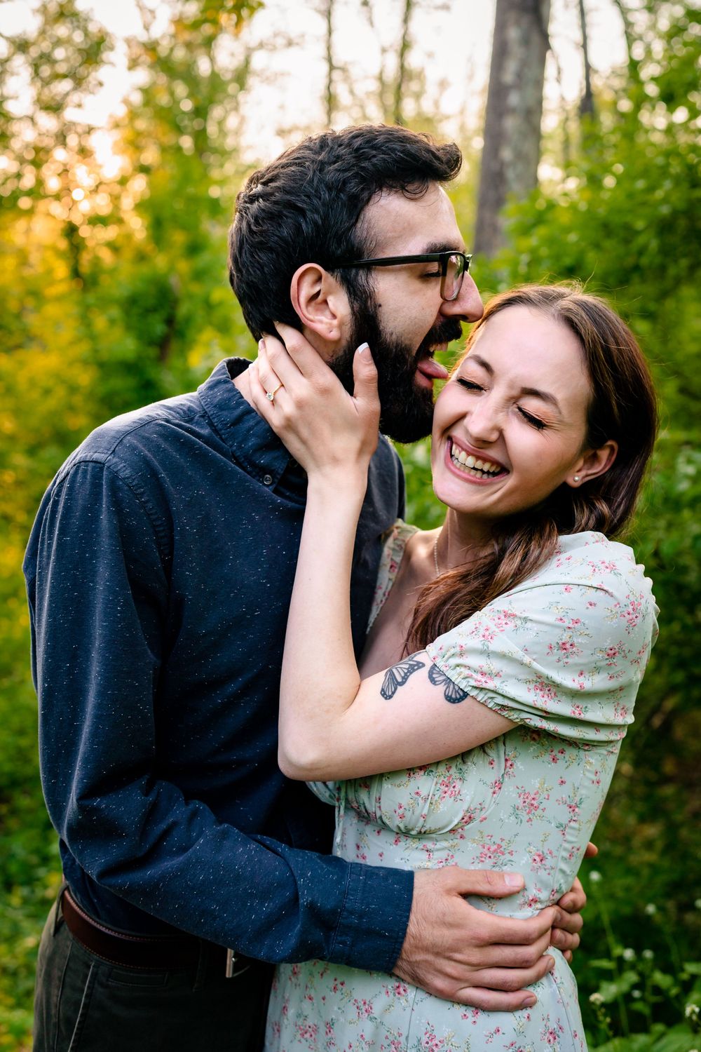 Candid moments of laughter and love between a couple in a sunlit forest.