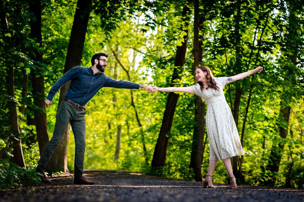 A playful pose on a forest path with outstretched arms creating a balanced composition.