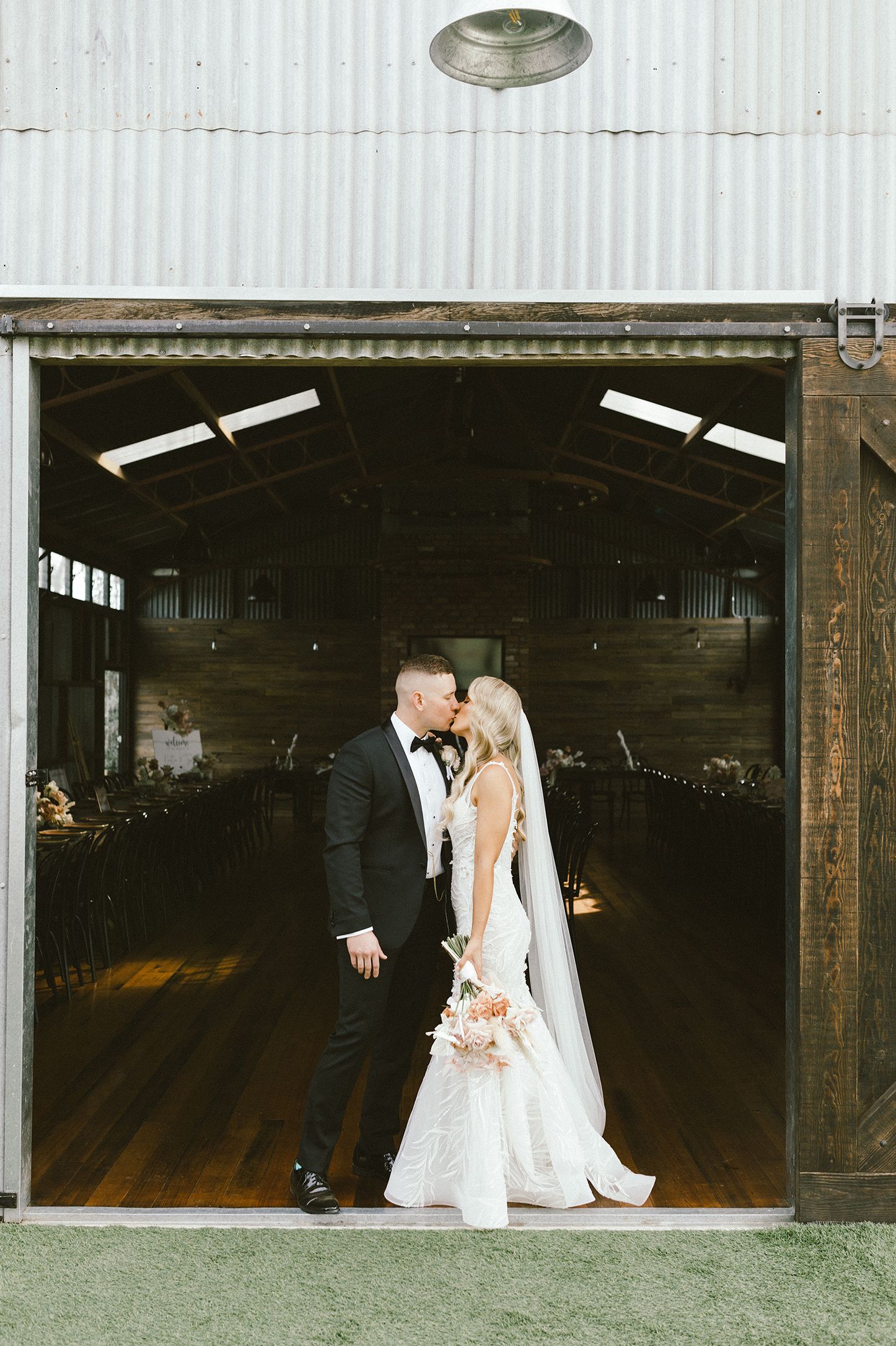 Wedding moment captured through industrial venue window frame.