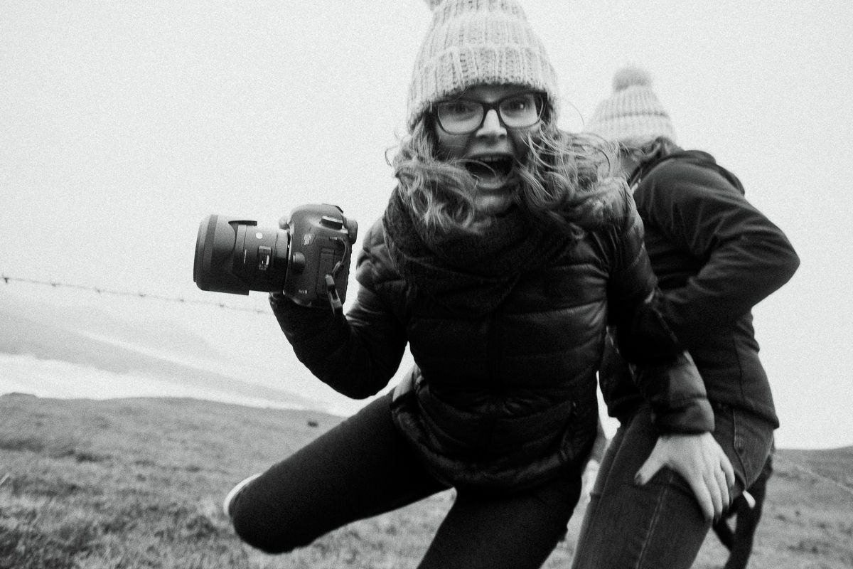 Black and white action shot of photographer with camera in outdoor setting.