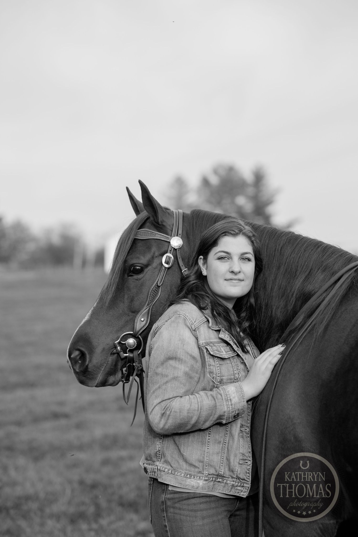 Black and white portrait showing a close bond between a horse and companion in a pastoral setting.