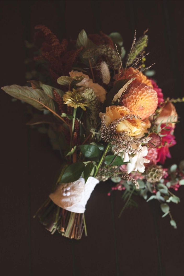 close up of a colorful wedding bouquet of peaches greens and pinks