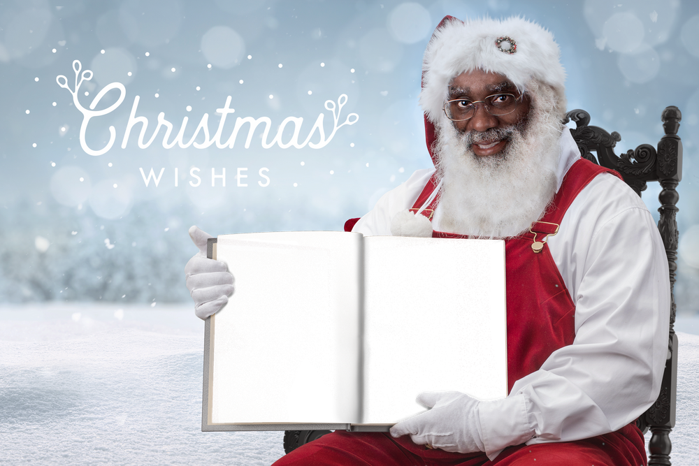 Santa sits holding a book.