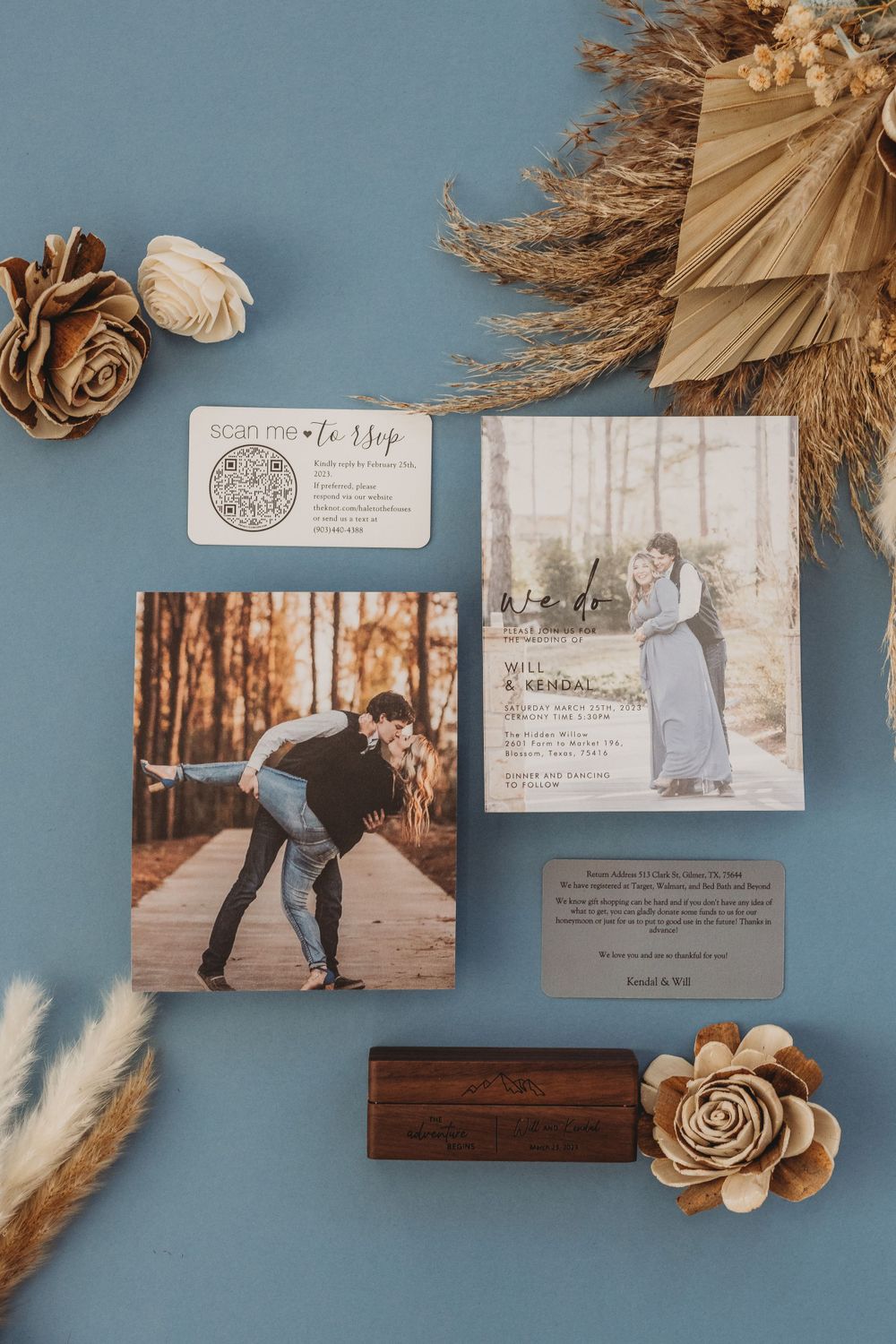 Wedding stationery and dried floral elements artfully arranged on a blue surface.