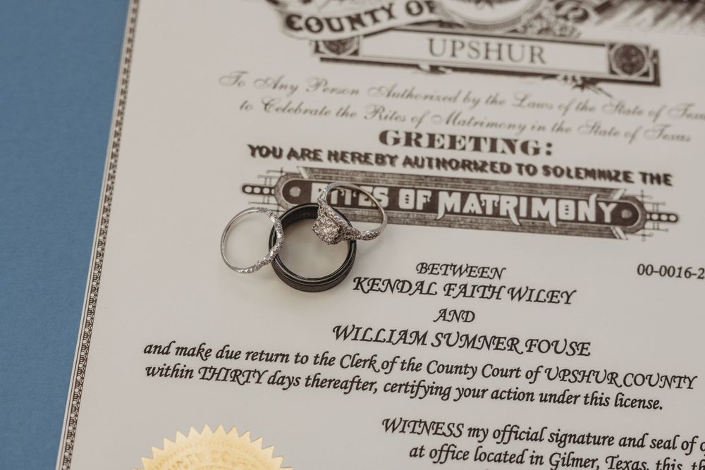 A close-up of an official marriage certificate with wedding rings.