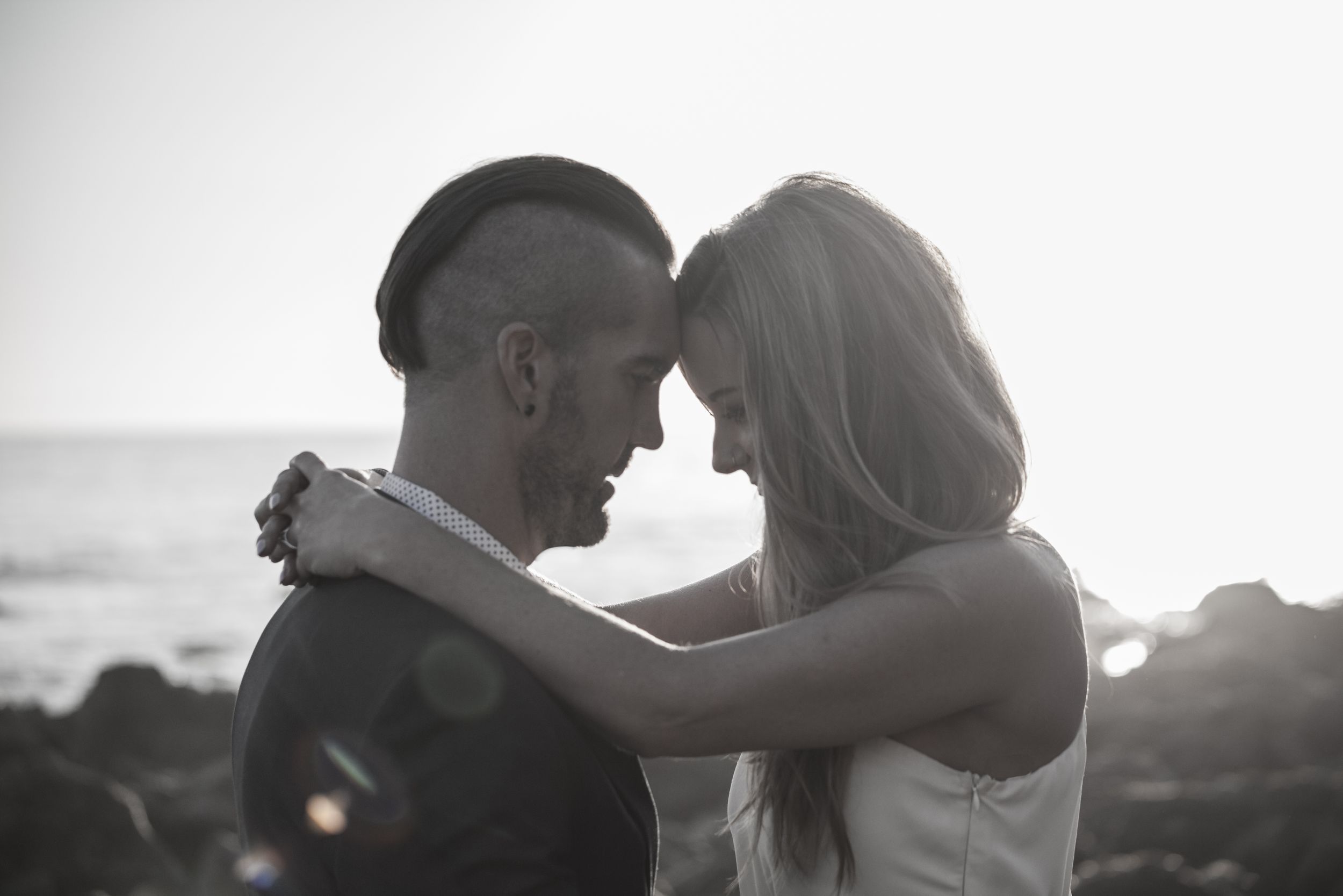Intimate black and white portrait of couple with foreheads touching.