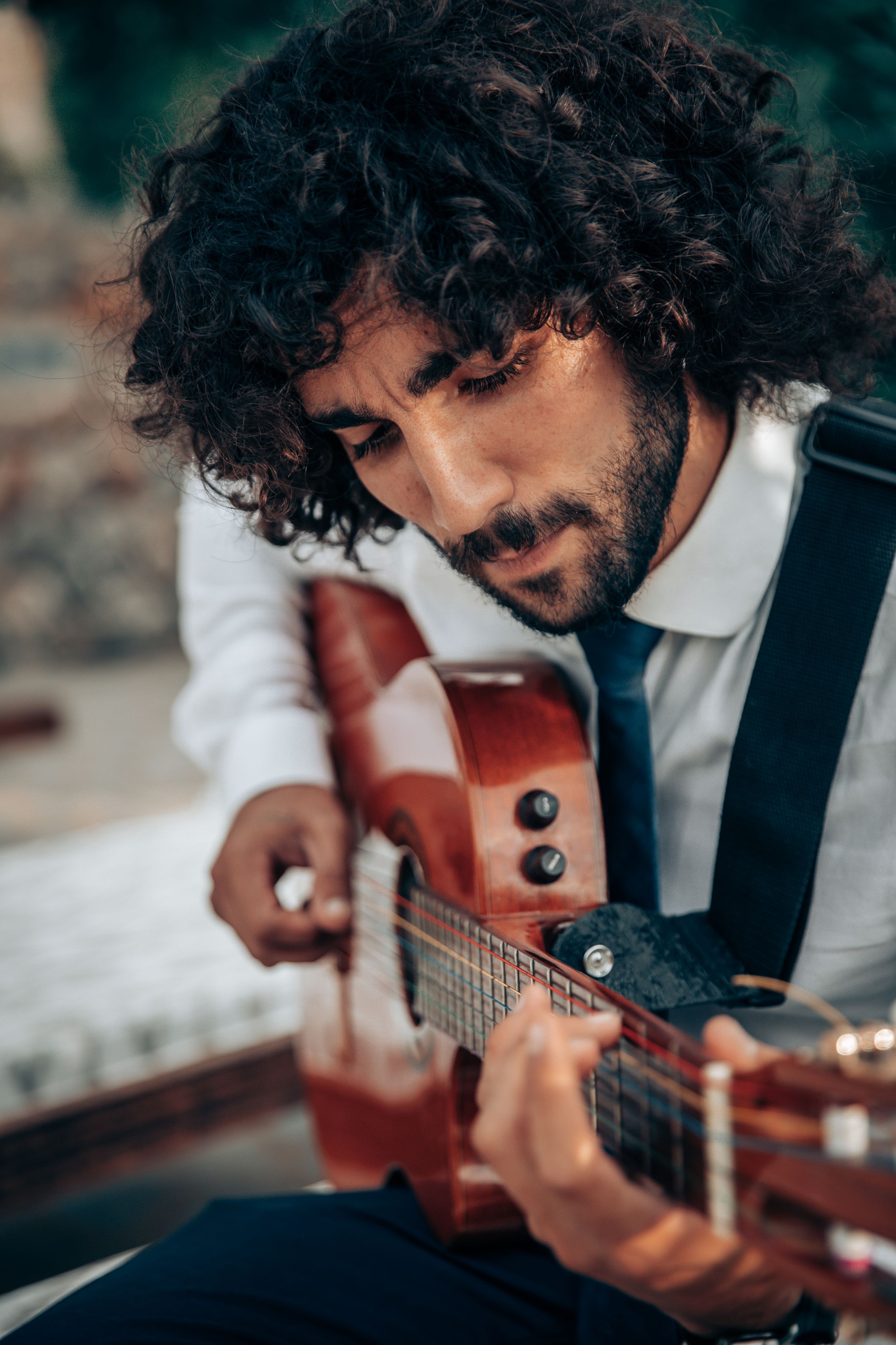 A musician playing acoustic guitar during alive cocktail hour music at an intimate boutique wedding in Mallorca.