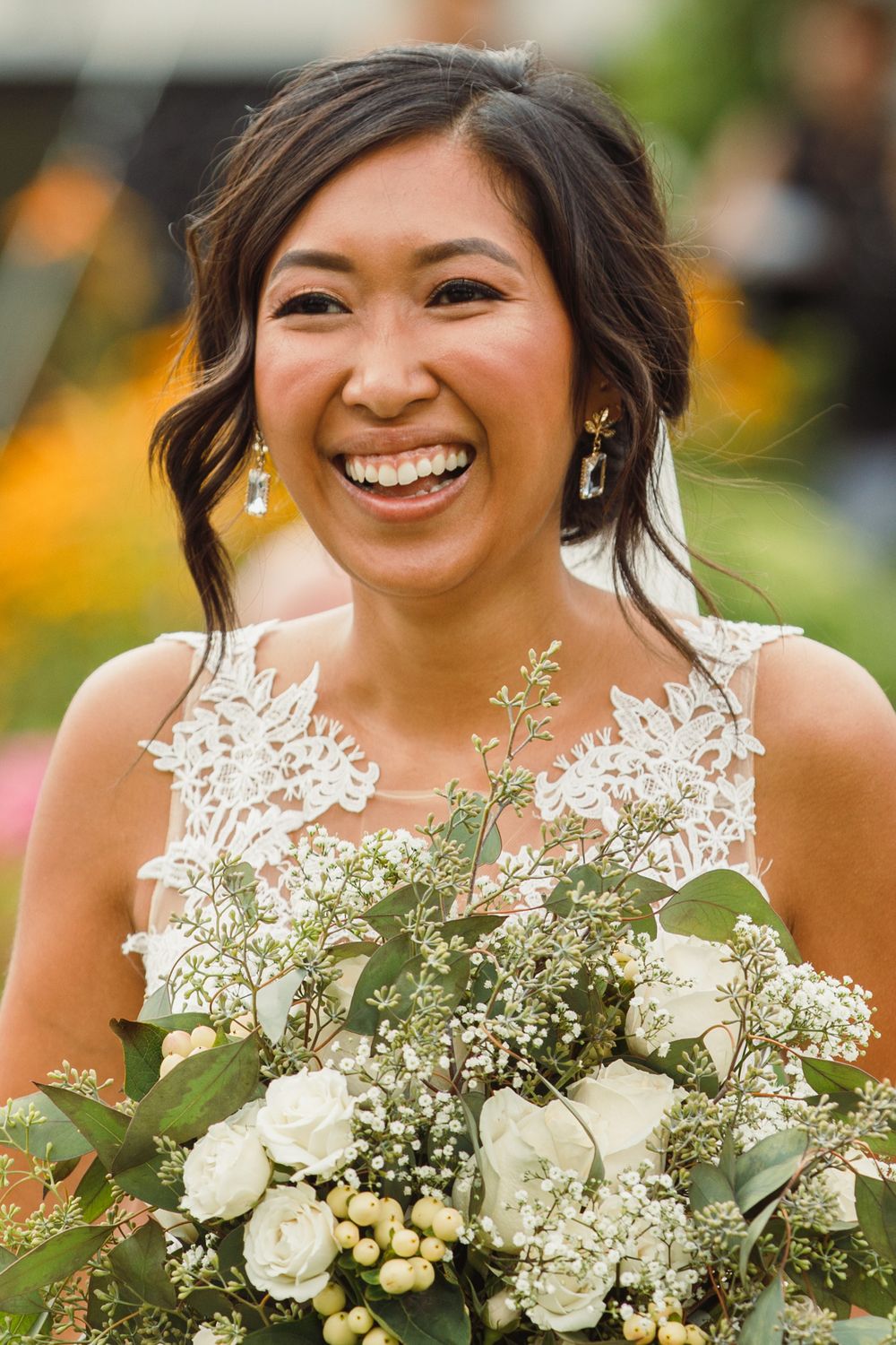 Close-up of a white and green bridal bouquet with roses and baby's breath.