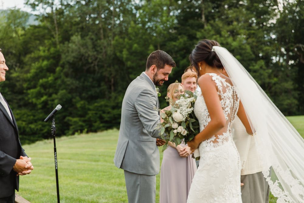 Intimate wedding ceremony moment captured in a lush green outdoor setting.