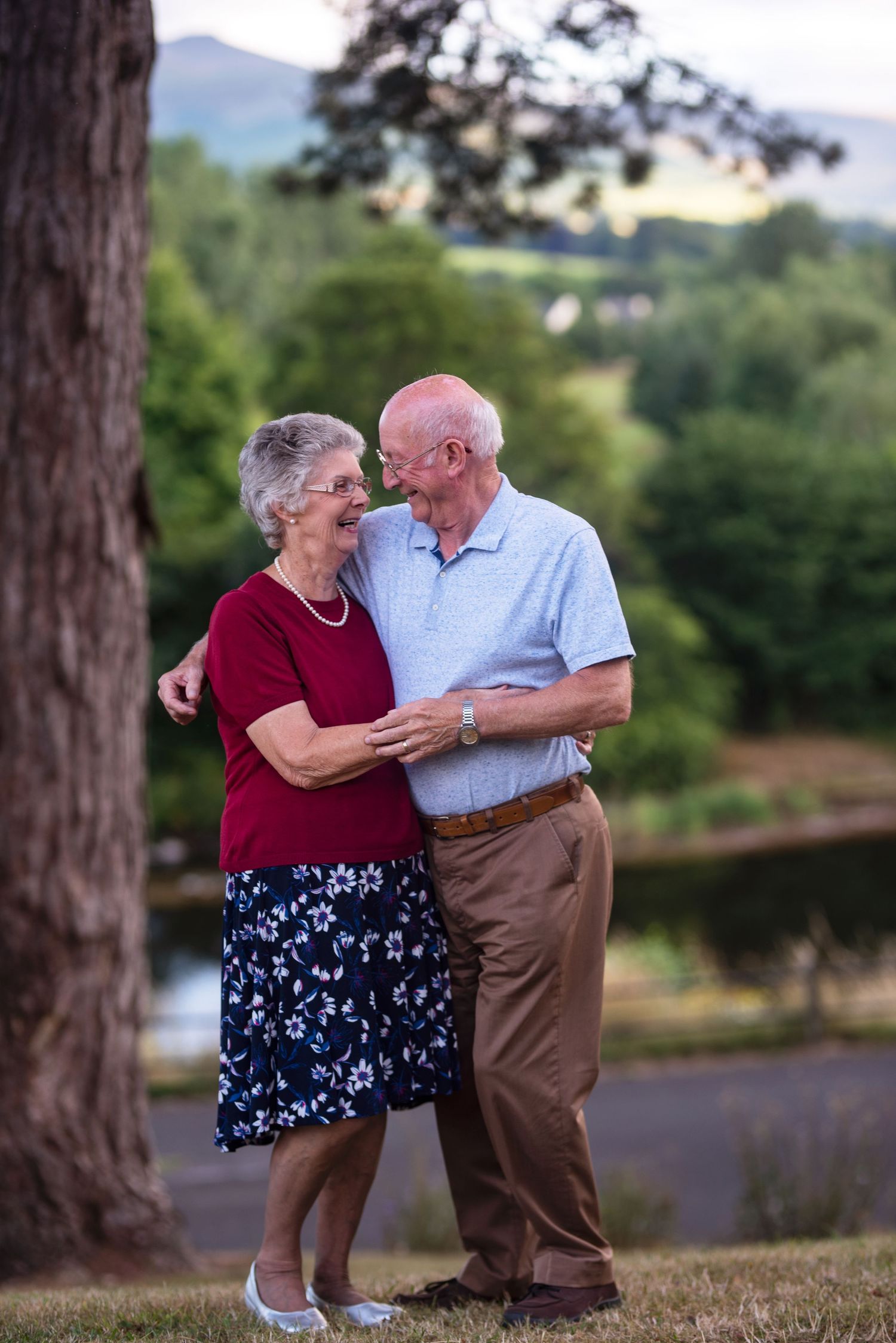 Dancing couple in a red and blue outfit with mountain backdrop.