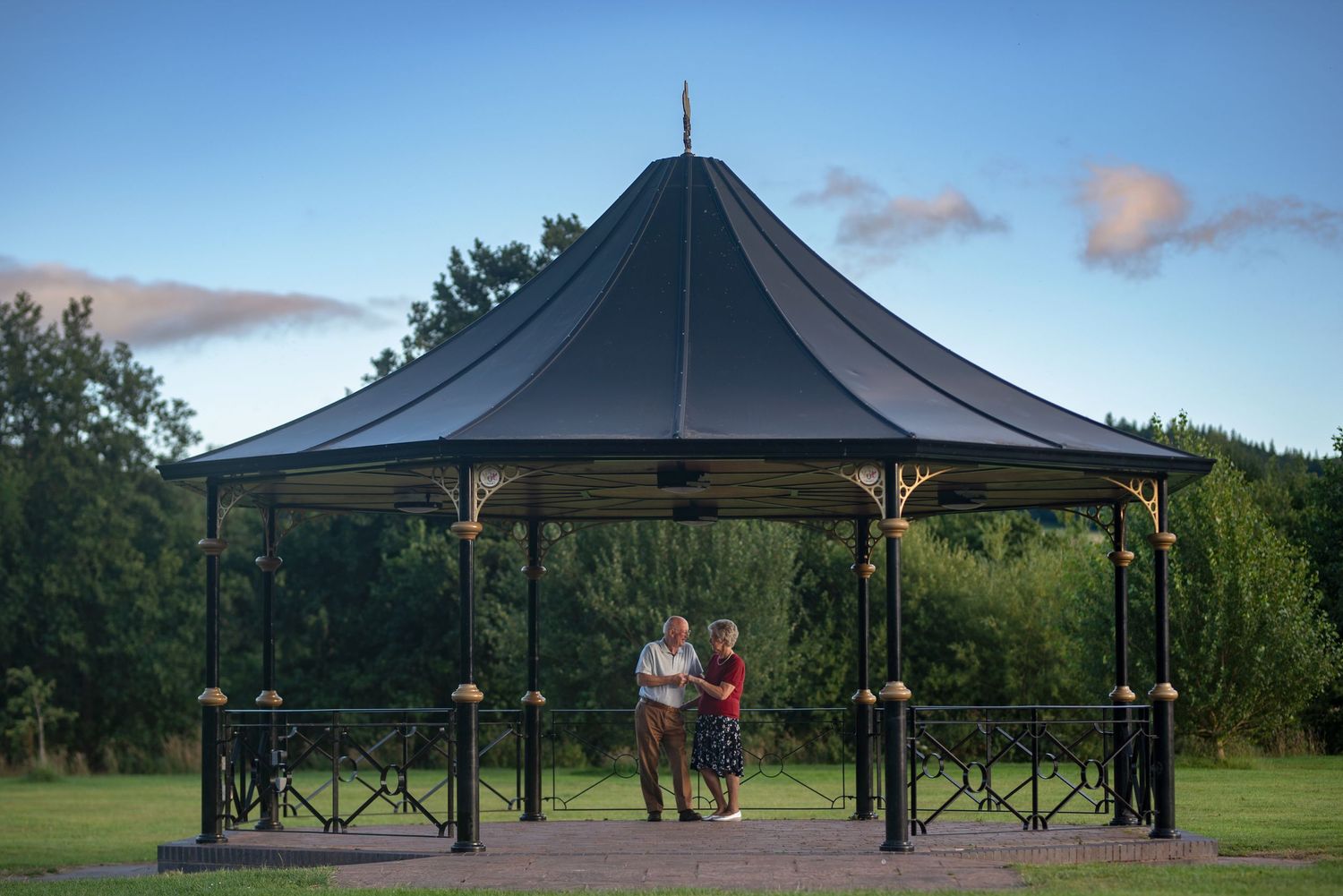 Large outdoor pavilion with black roof against blue summer sky.