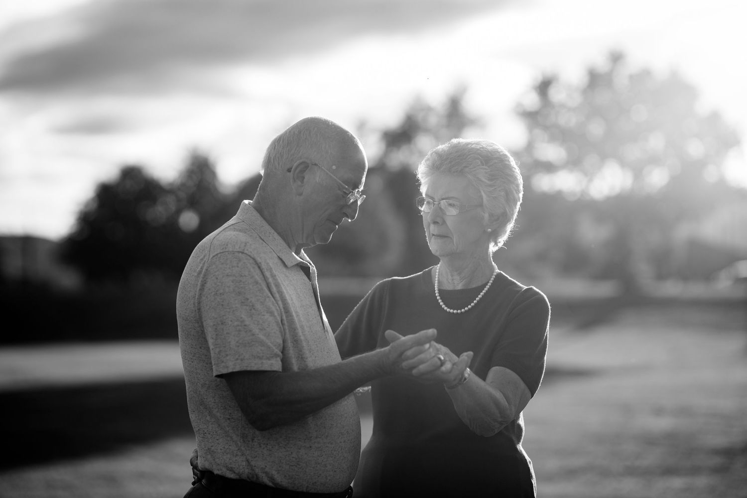 Romantic silhouette of a couple enjoying a quiet moment together on a bench at dusk.
