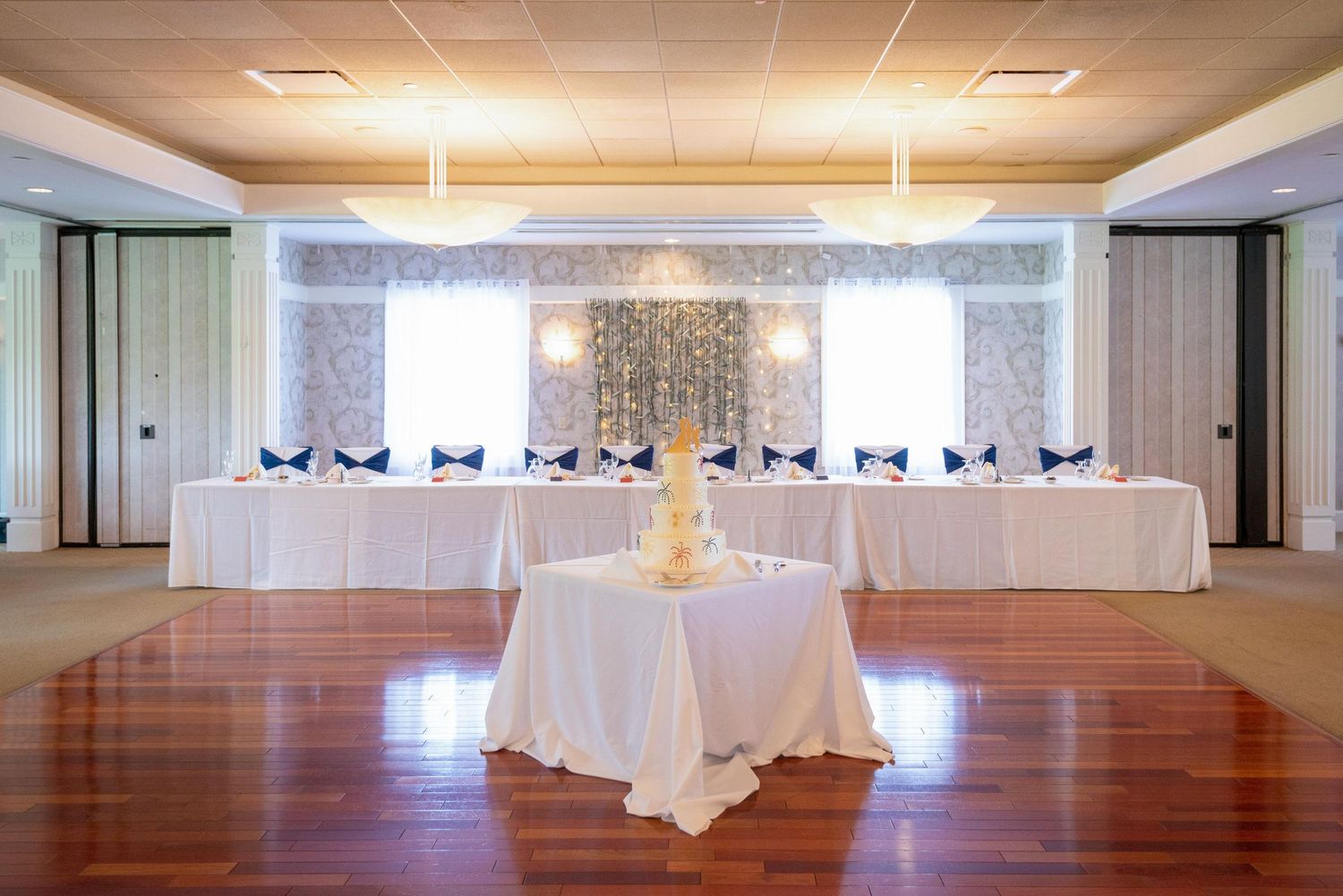 Large empty event space with white ceiling and hardwood floors ready for setup.