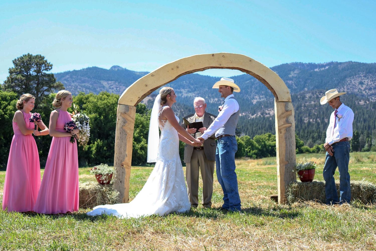 Ranch wedding ceremony with arch and mountains
