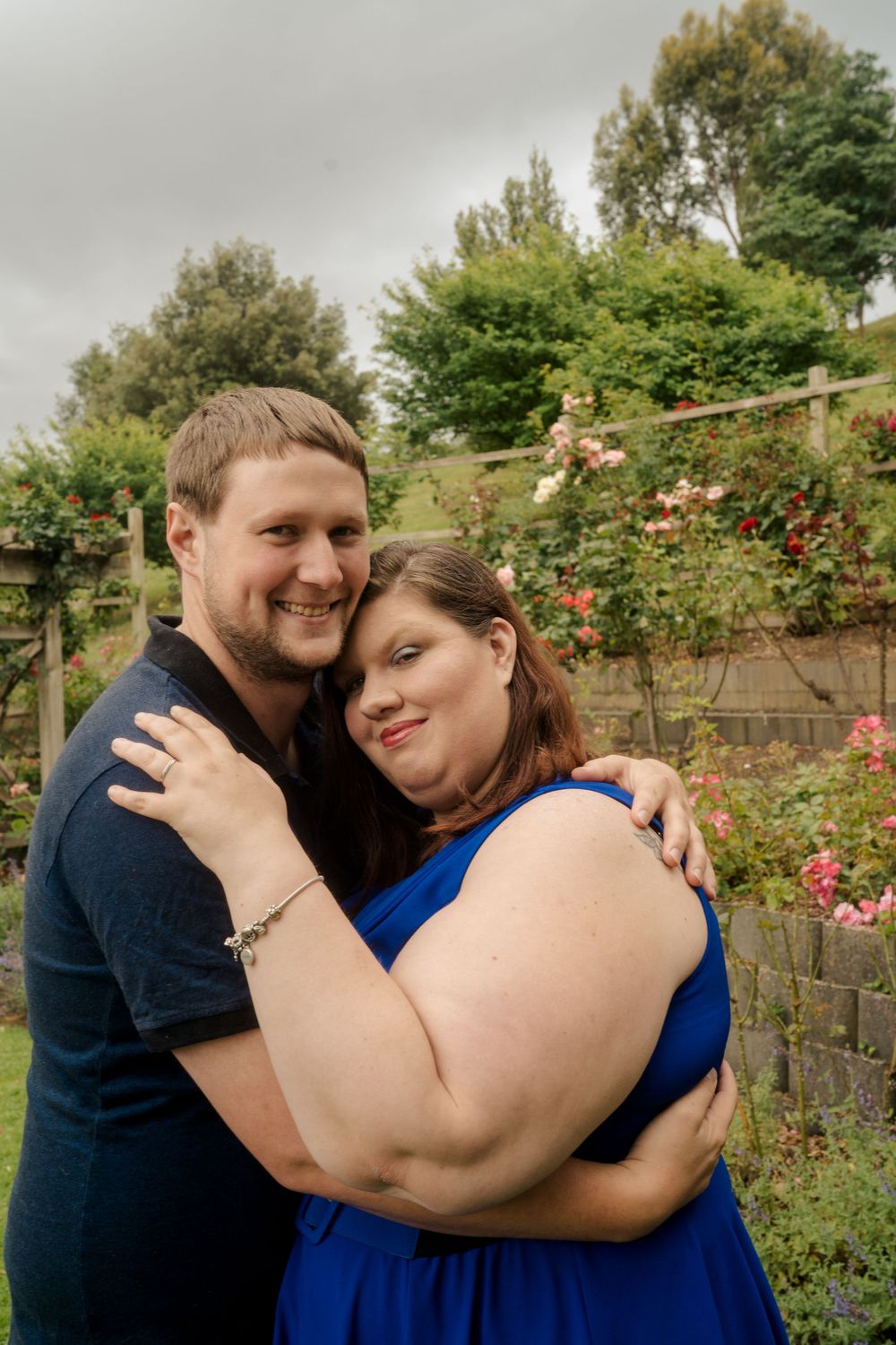 Man cuddling plus size fiance after accepting proposal