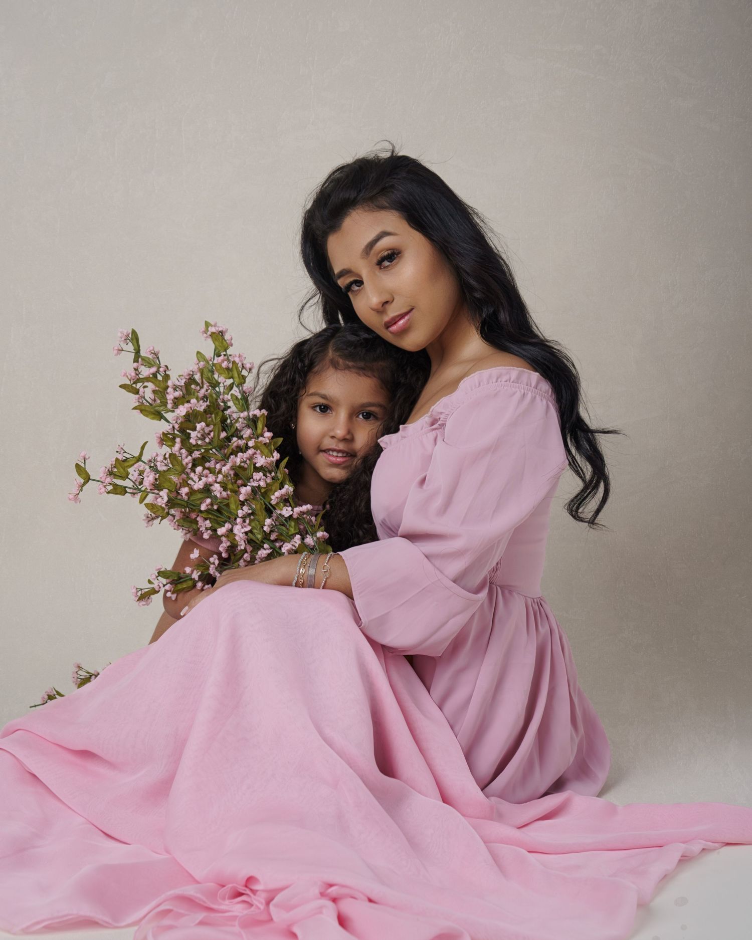 Studio portrait with pink floral dress and spring blossoms.