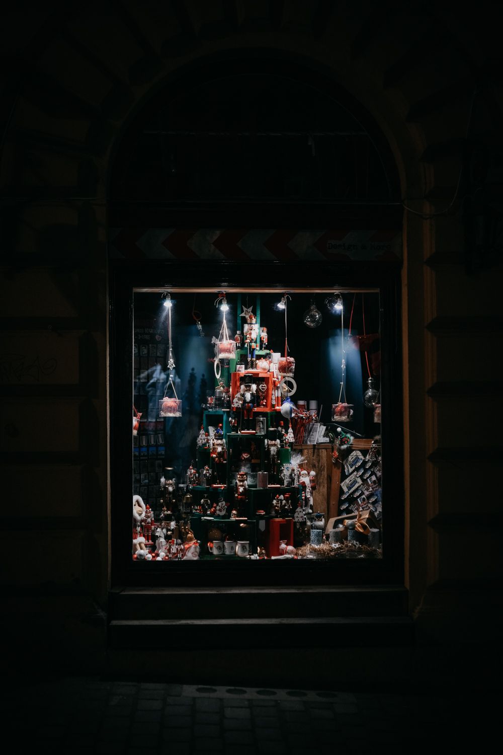 Illuminated Christmas display window showing a festive arrangement of decorations and lights.