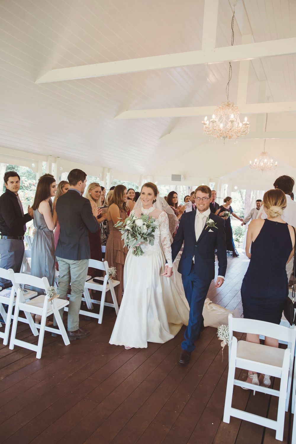 Bride and groom smiling as they walk back down the aisle after wedding