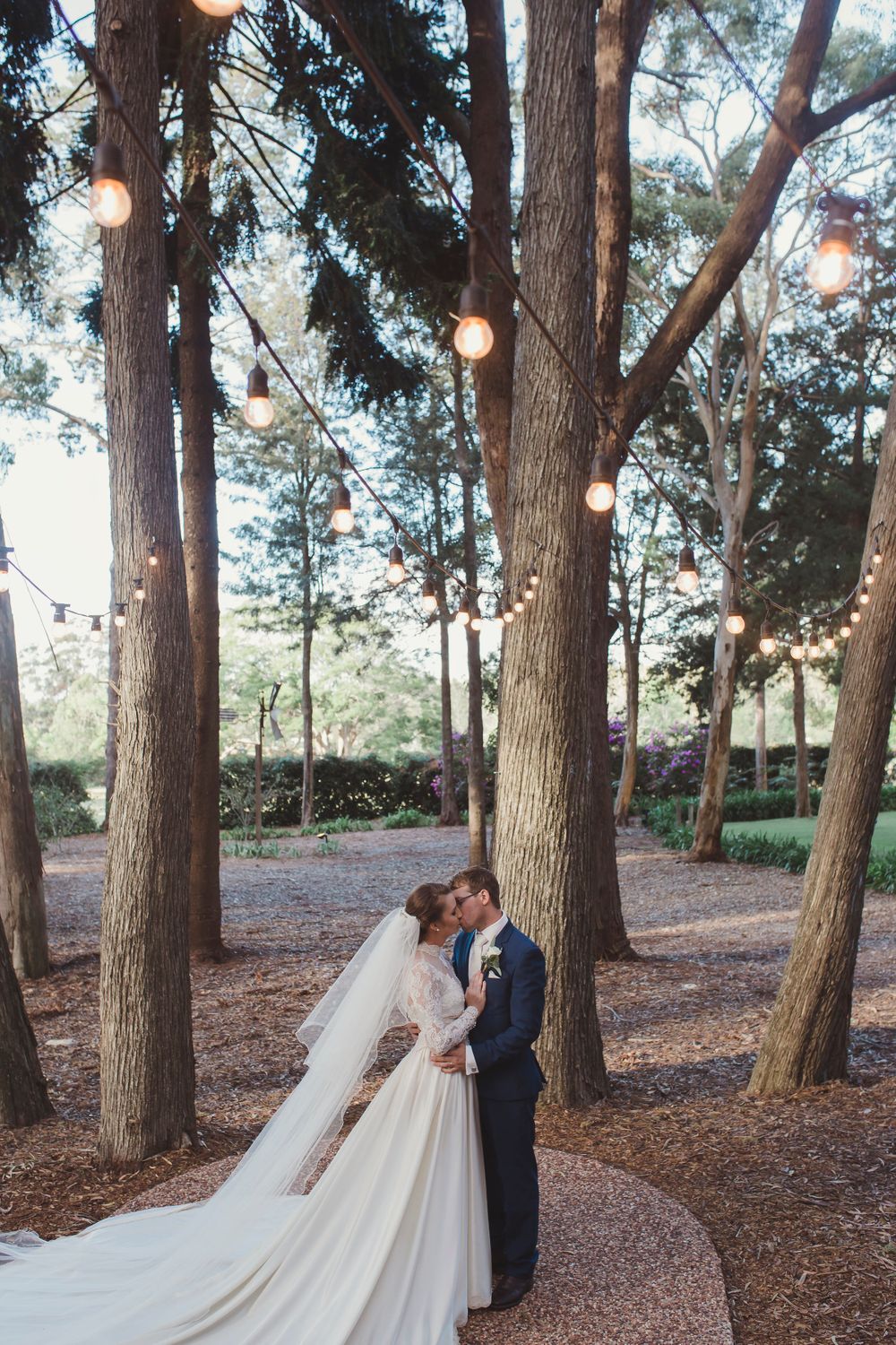 Bride and groom kissing under festoon lights at Gabbinbar Homestead wedding in Toowoomba