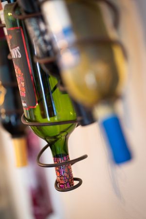 Artistic closeup of wine bottle in spiral holder with shallow depth of field.