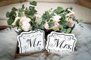 Elegant Mr. and Mrs. signs with white roses and eucalyptus wedding decoration.