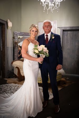 A formal portrait in an elegant room with a crystal chandelier and rustic doors.