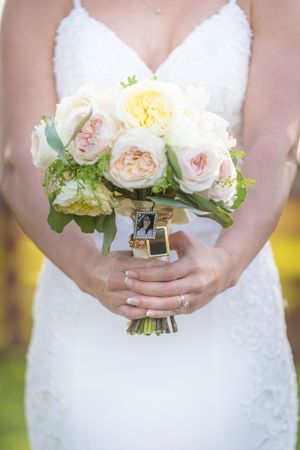 Elegant bridal bouquet featuring soft pink and white garden roses with greenery accents.