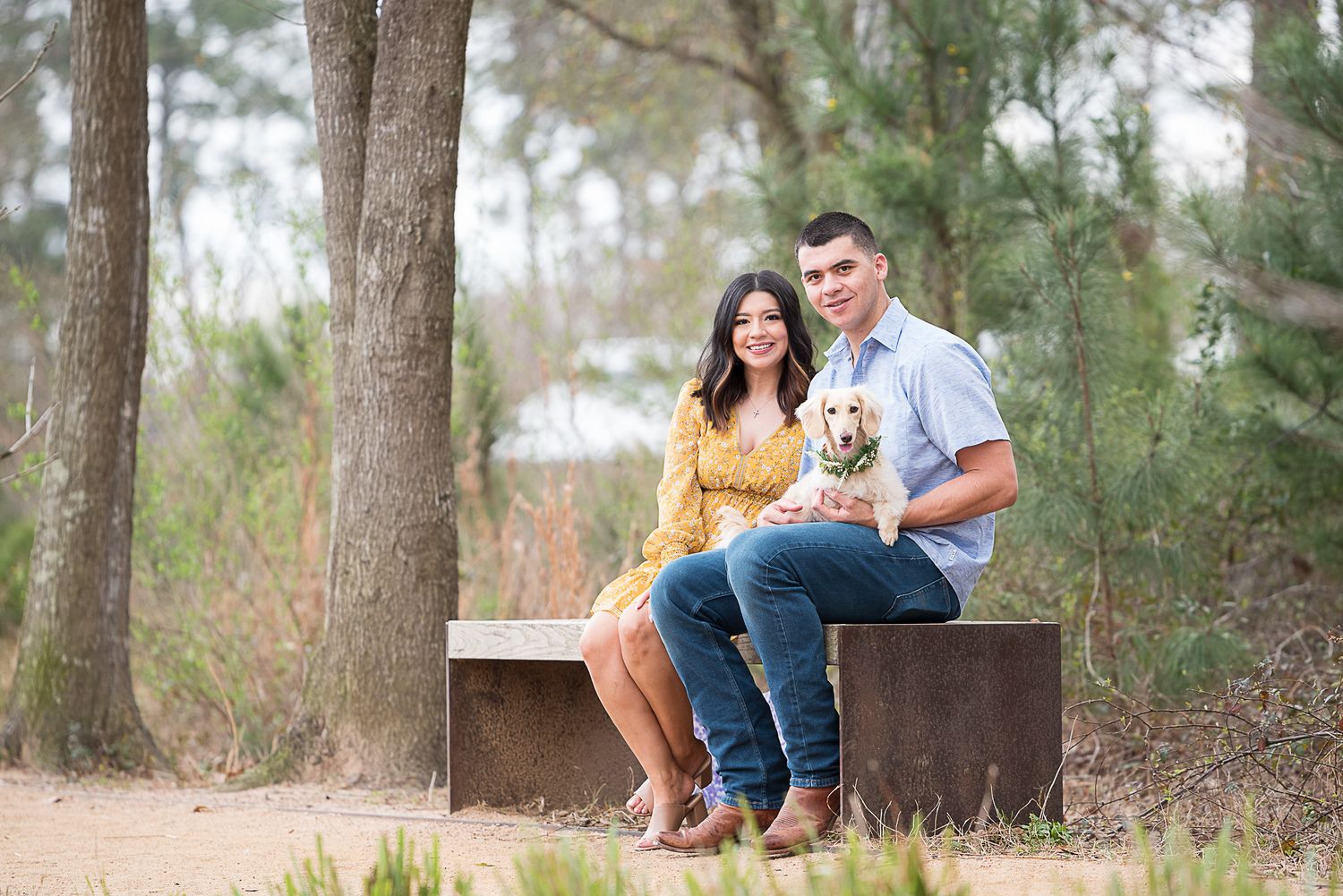 couple posing with their dog on a trail at Houston Memorial Park