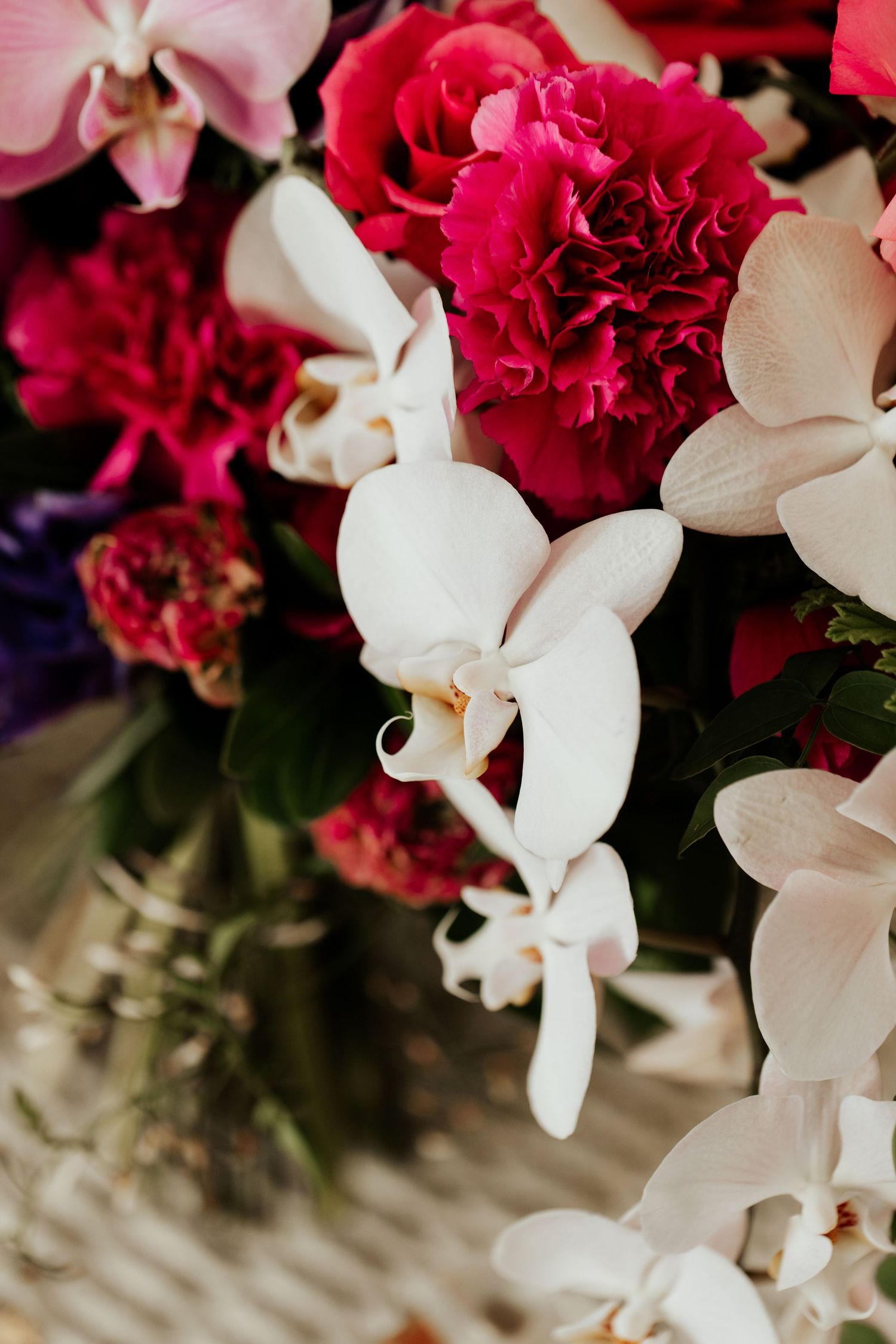 Stunning floral arrangement featuring bright red carnations and white orchids in elegant contrast.
