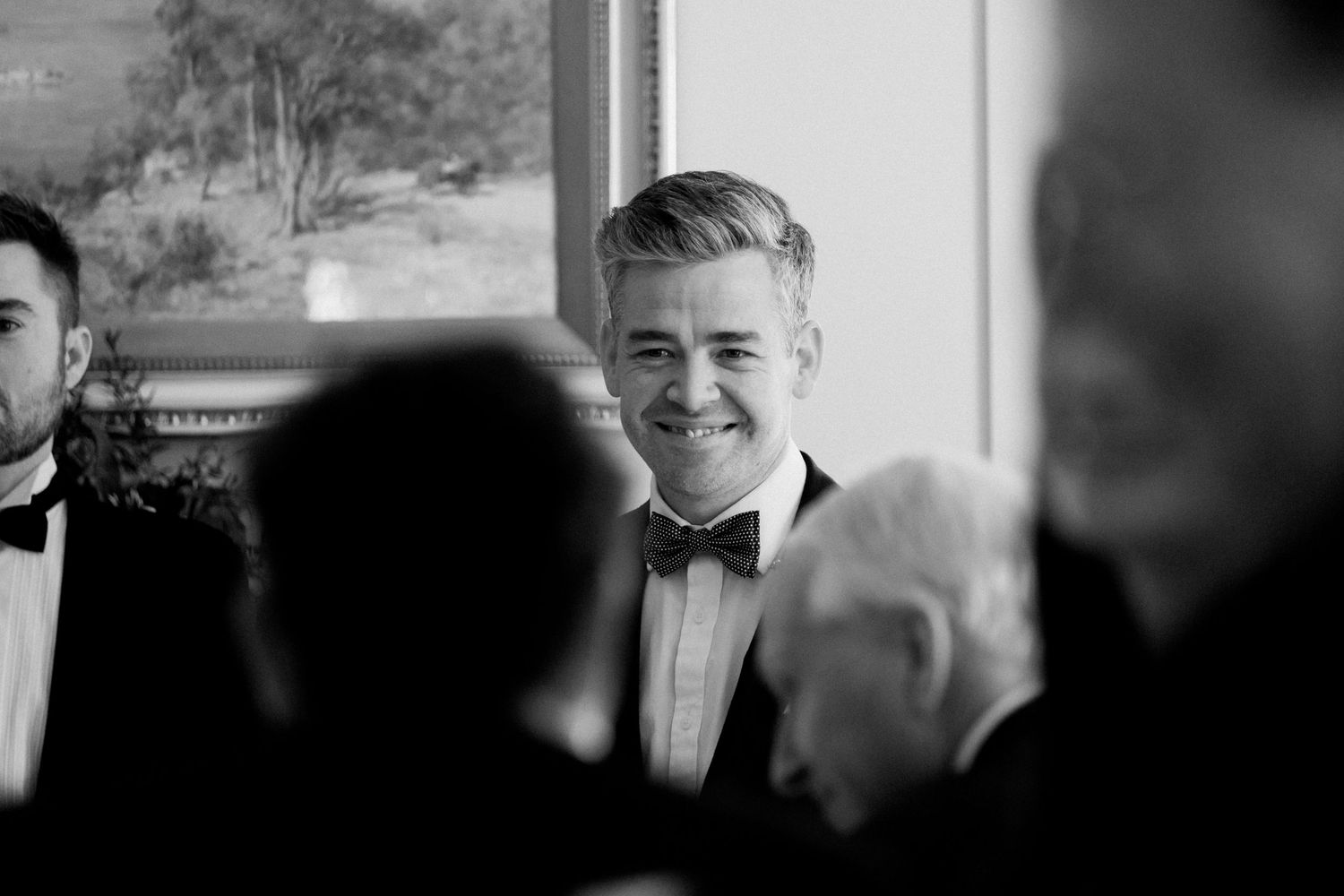 Black and white candid photo of formal event guests in bow ties.