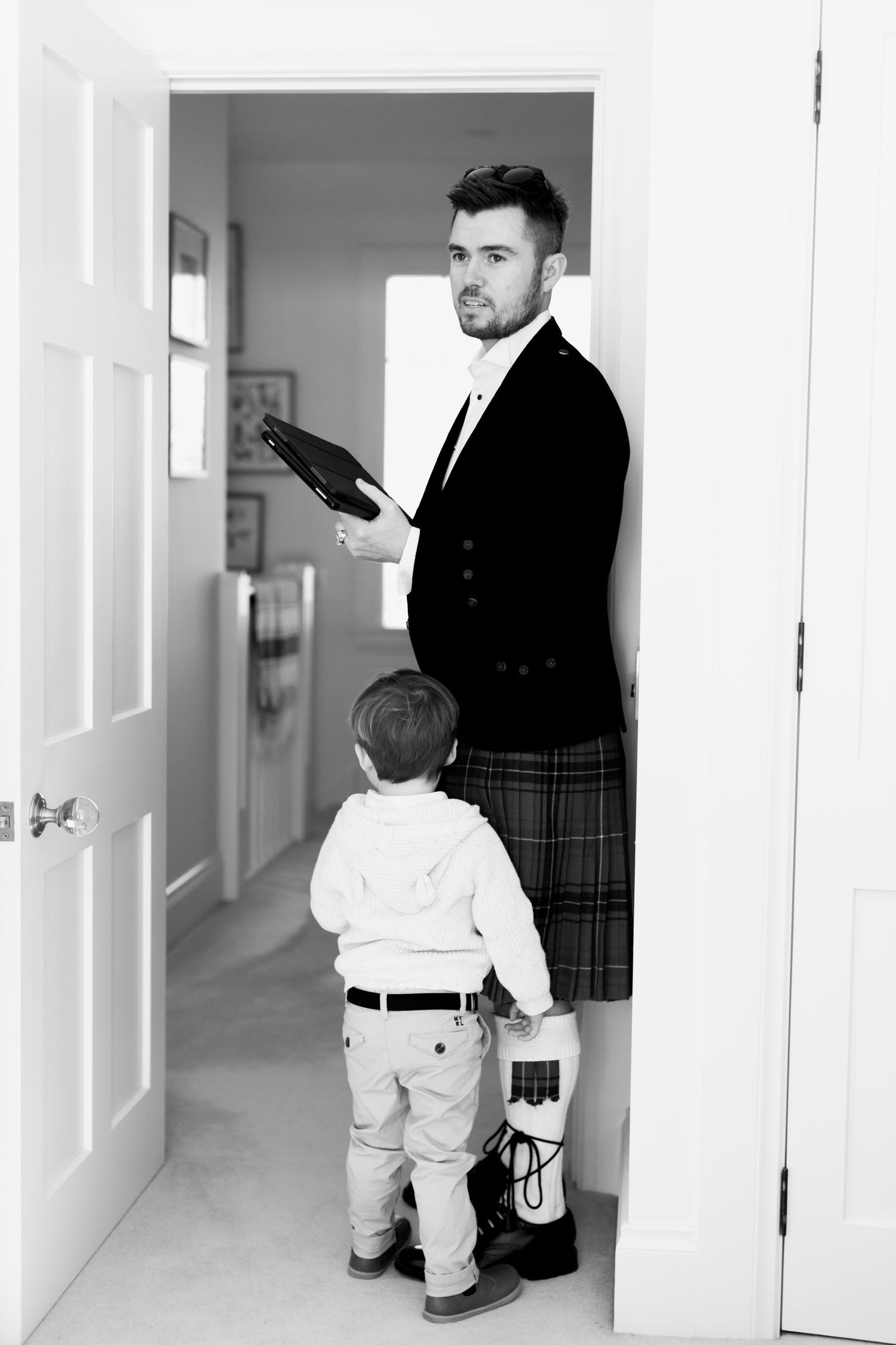 Formal attire preparation scene in hallway.
