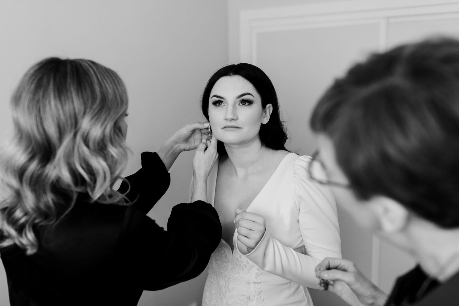 Wedding preparation scene with makeup artist working on final touches.