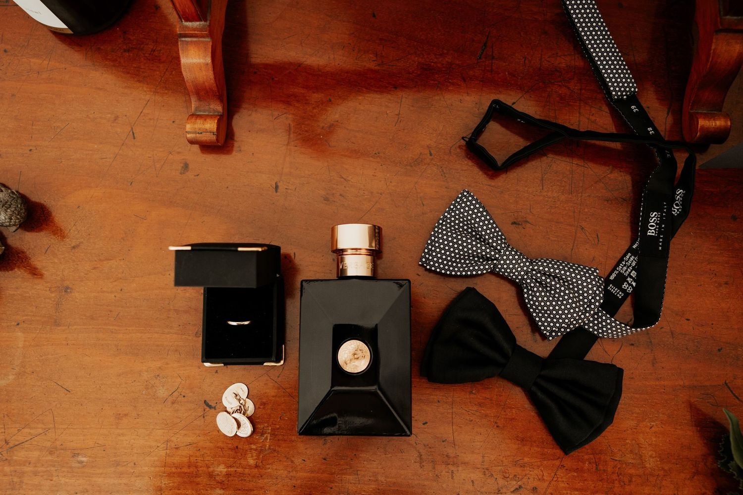 Black bow ties and cologne bottles arranged on a wooden surface.