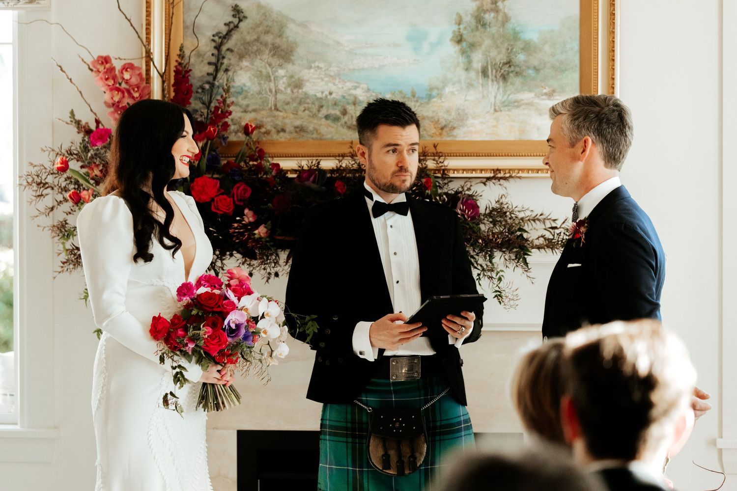A Scottish wedding ceremony with a groom wearing a traditional kilt standing at the altar.