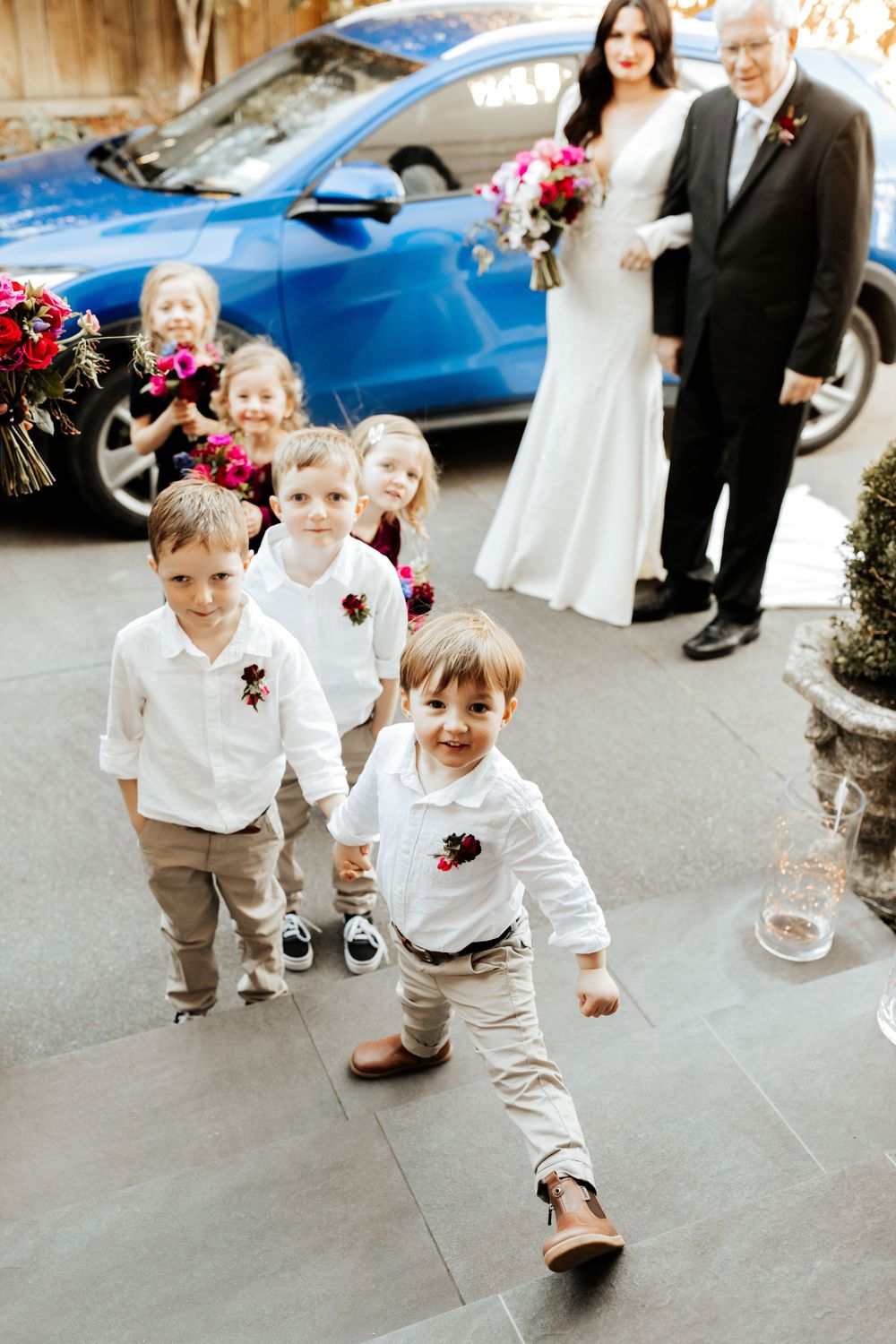 Wedding party with children in white shirts and khakis walking outside.