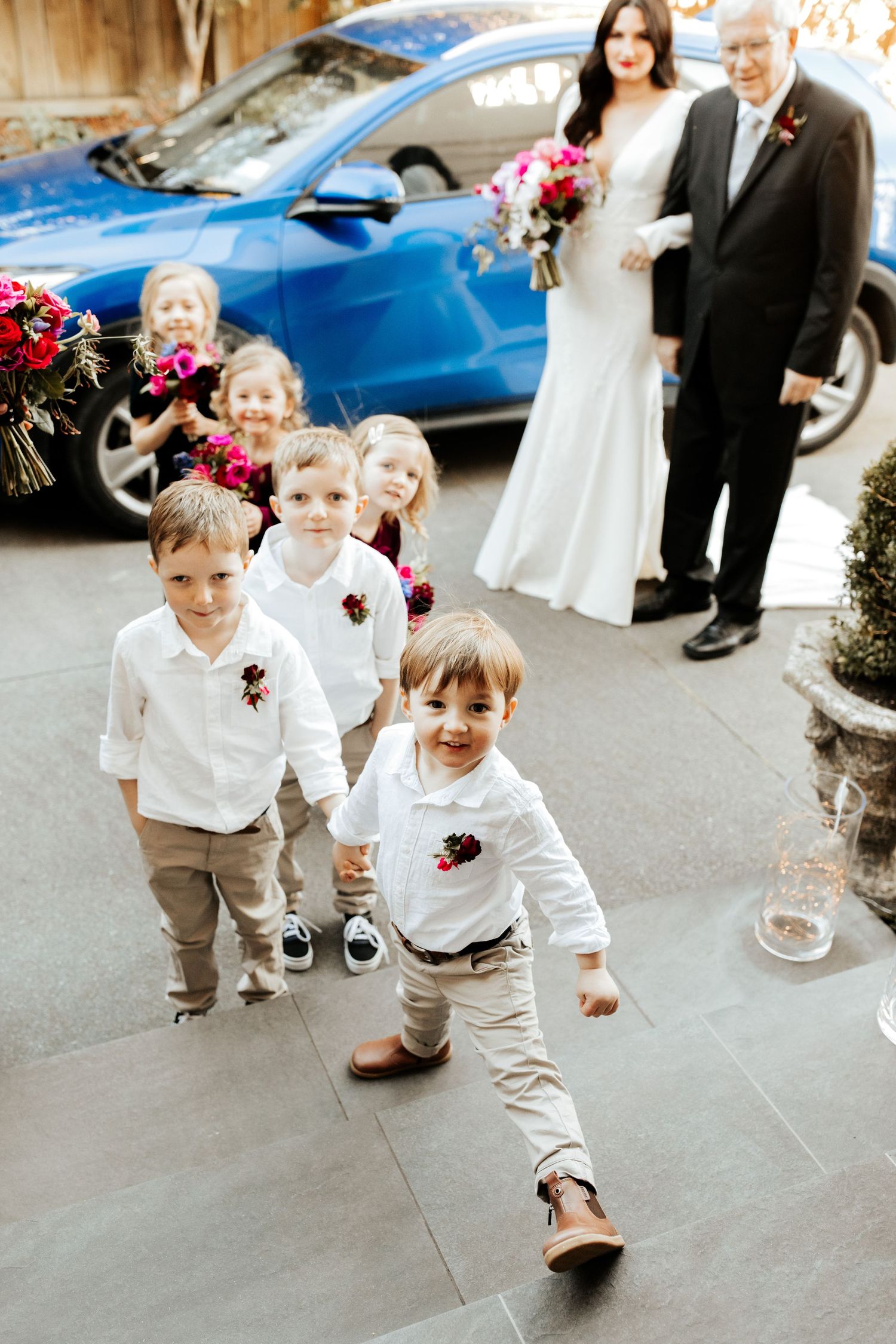 Wedding party with children in white shirts and khakis walking outside.
