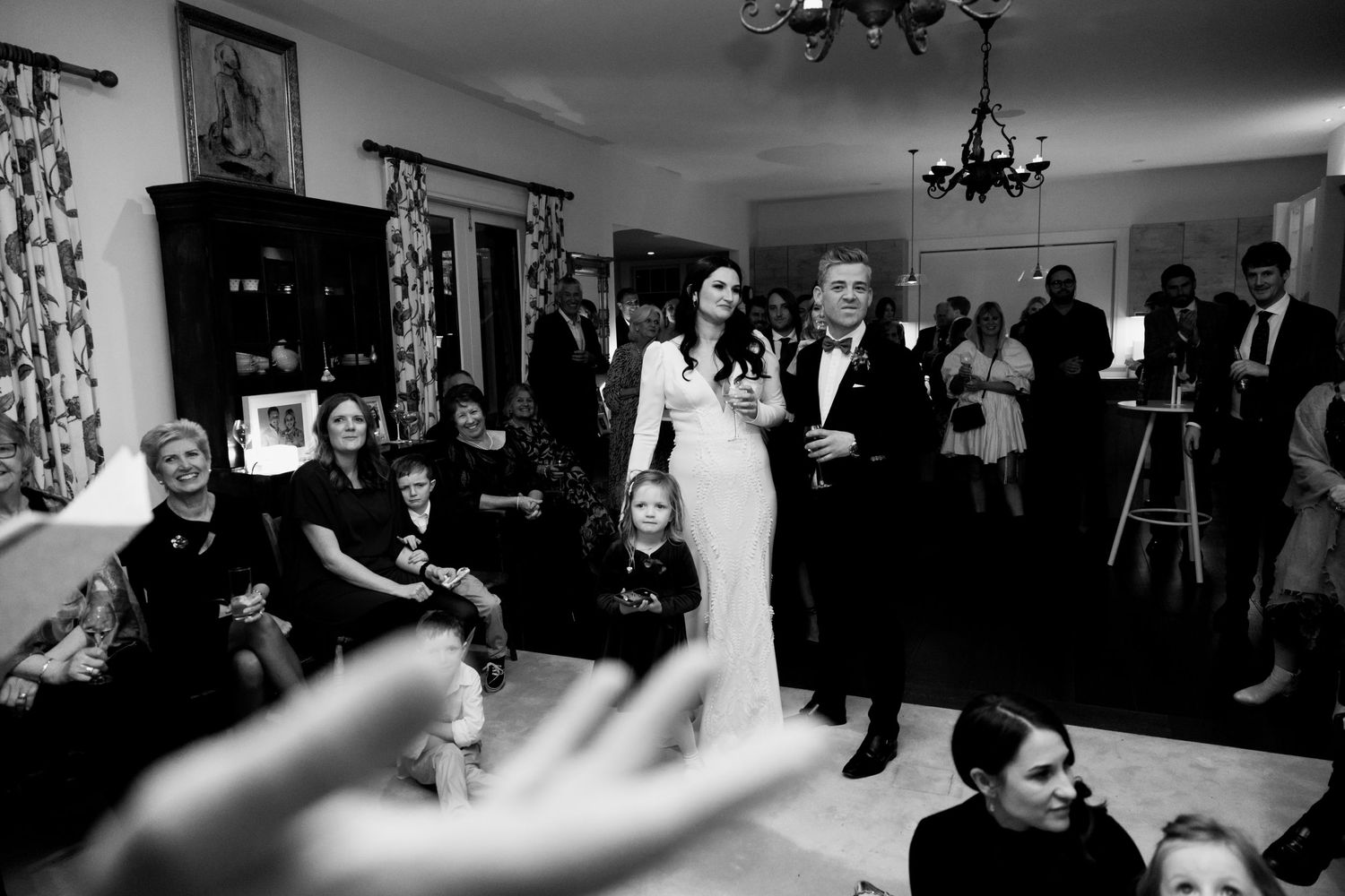 Black and white candid reception photo showing dancing and celebration at indoor venue.