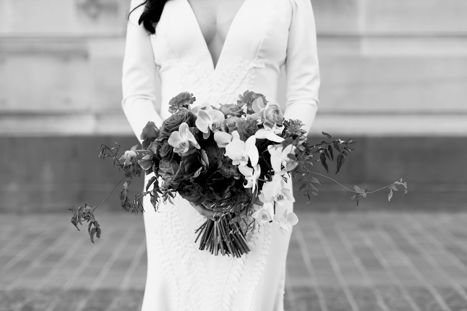 Black and white detail of wedding bouquet with cascading flowers and foliage.