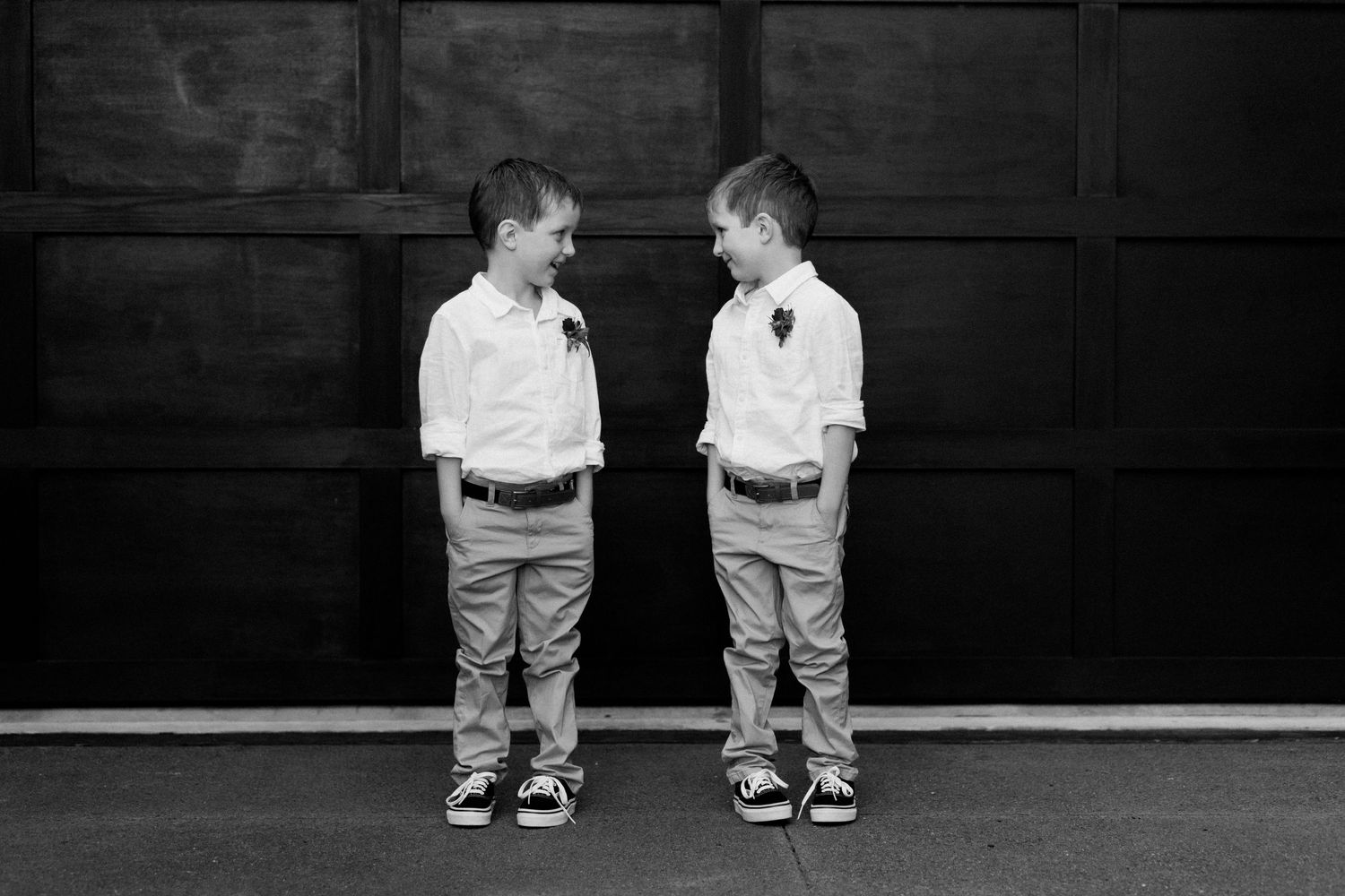 Black and white photo of two young boys in matching outfits.
