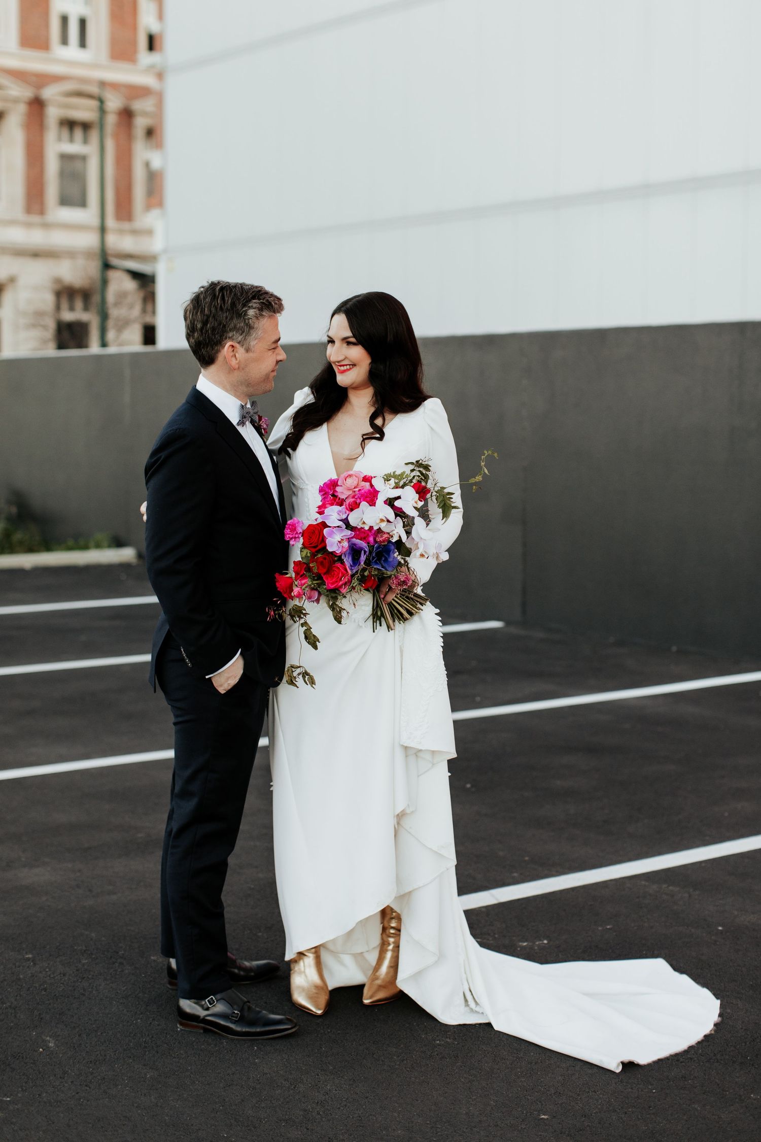 Intimate wedding portrait in parking lot with bride in flowing white gown.